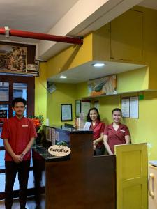 three people standing at a counter in a restaurant at Doña Mercedes in Cebu City