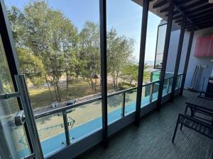 a balcony with a view of a park through windows at Pontian C Balcony in Kampong Bakek
