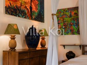a bedroom with a bed and two vases on a dresser at Villa Koi in Keramas