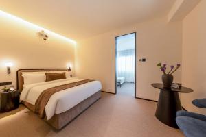 Postel nebo postele na pokoji v ubytování The Moment Hotel