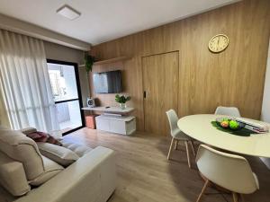 ein Wohnzimmer mit einer Couch, einem Tisch und einer Uhr in der Unterkunft Apartamento Mobiliado Belém COP30 in Belém