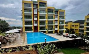 an apartment building with a swimming pool in front of it at Forest Frame - Kudrat Nilaya Valley View with pool in Canacona