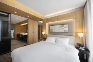 Gochang Wellpark Hotel Gochang的一间带白色床的卧室和一间浴室