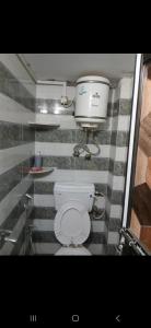 ein Badezimmer mit einem WC und einem Eimer an der Wand in der Unterkunft Kashvi Homestay in Varanasi