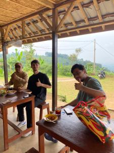 a group of three men sitting at a table at Bule Homestay Cianjur in Cianjur