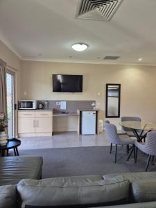 una sala de estar con un sofá y una mesa en Pittsworth Motor Inn, en Pittsworth