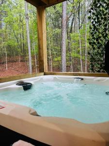 a jacuzzi tub in the middle of the woods at Lux Blue Ridge Cabin, Hot tub, Swing, PingPong! in Mineral Bluff