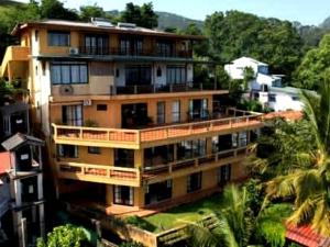a large apartment building with balconies and palm trees at Kandy Highland Unique Hotel in Kandy