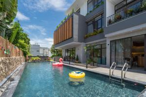 an outdoor swimming pool with an inflatable pool noodle in a building at Sora Villa, 4BDR, Large Pool & Elevator Access in Da Nang