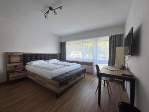a bedroom with a bed and a desk and a deskablish at Chesa in Selva in St. Moritz