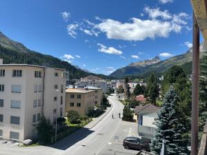a street in a town with mountains in the background at Chesa in Selva in St. Moritz