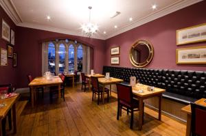 a restaurant with tables and chairs and a bench at The Corner House Hotel in Taunton