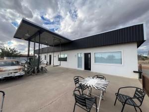 a patio with chairs and a car and a building at Pik Pak in Marfa