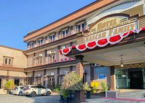 Un hotel con coches aparcados delante. en Hotel Nascar Famili, en Palangkaraya