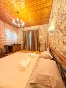 a bedroom with two beds and a stone wall at Old Balcony in Kutaisi