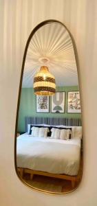 a mirror in a bedroom with a bed and a chandelier at The View on Castle Hill with Lovely Hot Tub in Conwy