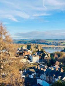 a small town with a castle and a body of water at The View on Castle Hill with Lovely Hot Tub in Conwy