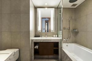 a bathroom with a tub and a sink and a mirror at LOTTE City Hotel Gimpo Airport in Seoul