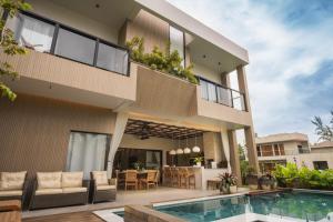 a house with a balcony and a swimming pool at Casa Pura Vida in Maragogi
