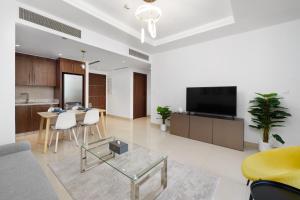 a living room with a tv and a table with chairs at Stunning 1 Bedroom at Boulevard Point with Infinity Pool connected to Dubai Mall by Luxury Space in Dubai