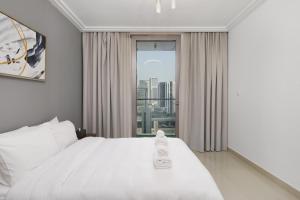 a bedroom with a white bed and a window at Stunning 1 Bedroom at Boulevard Point with Infinity Pool connected to Dubai Mall by Luxury Space in Dubai