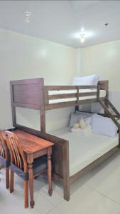 a bedroom with a bunk bed and a table and a chair at Baguio Condo Transient Grand View Unit314 by Dei Gratia in Baguio