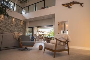 a living room with two chairs and a couch at Casa Pura Vida in Maragogi