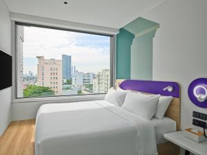 岘港Tru by Hilton Da Nang City Centre的卧室里有一张白色的床和一扇大窗户