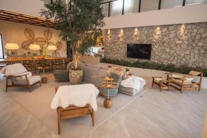 a lobby with furniture and a tv on a stone wall at Casa Pura Vida in Maragogi