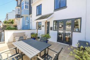 eine Terrasse mit Tisch und Stühlen vor einem Haus in der Unterkunft Armada Cottage in Dartmouth