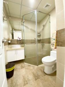 a bathroom with a shower and a toilet and a sink at Monarchy Luxury Serviced Apartments - By Charm Homestay Vietnam in Da Nang