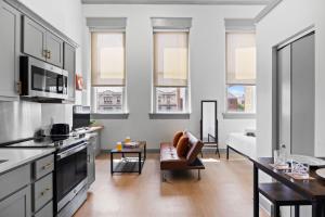 a kitchen and living room with a couch and a table at Bright and Modern Studio in Louisville # 303 in Louisville