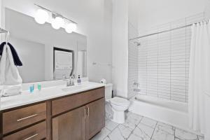 a bathroom with a sink and a toilet and a tub at Bright and Modern Studio in Louisville # 303 in Louisville