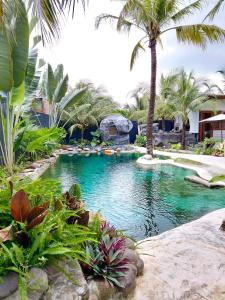 a pool with palm trees in a resort at Cóc Retreat Mỹ Tho City in My Tho