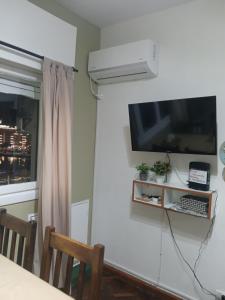a room with a television and a table with chairs at Departamento Monoambiente Centro Villa Carlos Paz in Villa Carlos Paz