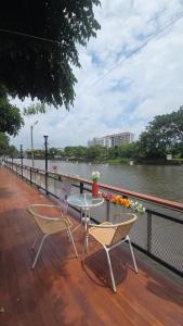 a patio with two chairs and a table next to a river at Grace Riverfront in Lat Krabang