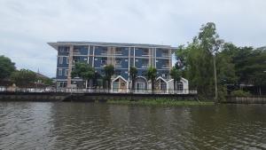 a large blue building next to a body of water at Grace Riverfront in Lat Krabang