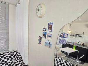 a room with a table and a clock on a wall at Ilgwang 2Floor House in Busan