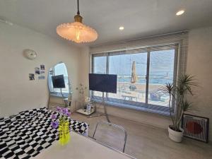 a living room with a large window and a television at Ilgwang 2Floor House in Busan