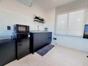 a kitchen with a black refrigerator and a window at Ilgwang 2Floor House in Busan
