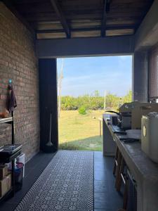 a kitchen with a view of a field in the distance at 1 Unit 'Rumah Singgah' Minimalist Concept House in Kg Mangkok, Penarik Terengganu in Kampong Mangkok
