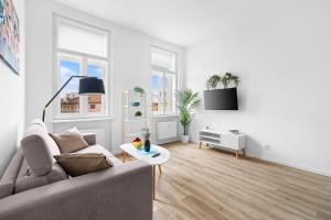a white living room with a couch and a table at HideOut Apartments in Brno