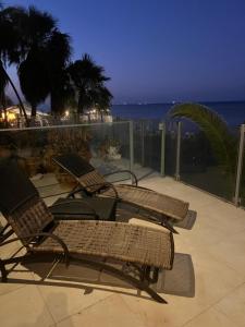 two chairs and a table on a patio with the ocean at Sandy Kisses in Larnaka