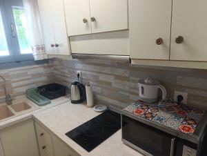 a kitchen with white cabinets and a stove top oven at Just another in Skiros