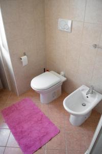 a bathroom with a white toilet and a sink at la terrazza del borgo con parcheggio in Malcesine +15 photos