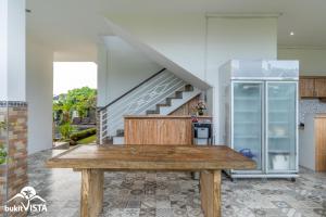 a kitchen with a wooden table and a refrigerator at Pondok Bagus by Bukit Vista in Canggu