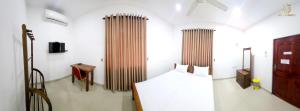a room with a bed and two tall curtains at Urban Breeze in Kundasale +34 photos