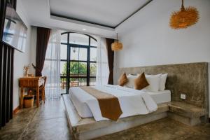 a bedroom with a bed and a desk and a window at Nuansa Penida Hostel in Nusa Penida