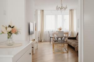 un soggiorno bianco con tavolo e divano di Wita Stwosza Rynek Apartament Wrocław a Breslavia