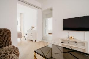 un soggiorno con una TV a schermo piatto su una parete di Wita Stwosza Rynek Apartament Wrocław a Breslavia